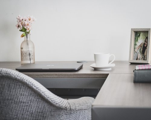Woman stretching arms at home office desk